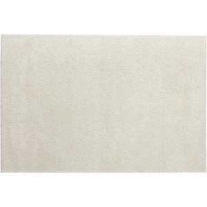 Tappeto moderno a tinta unita in beige chiaro.