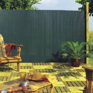 Frangivista verde t.b.t. in canna, come protezione della privacy in giardino, montato su una recinzione di legno.