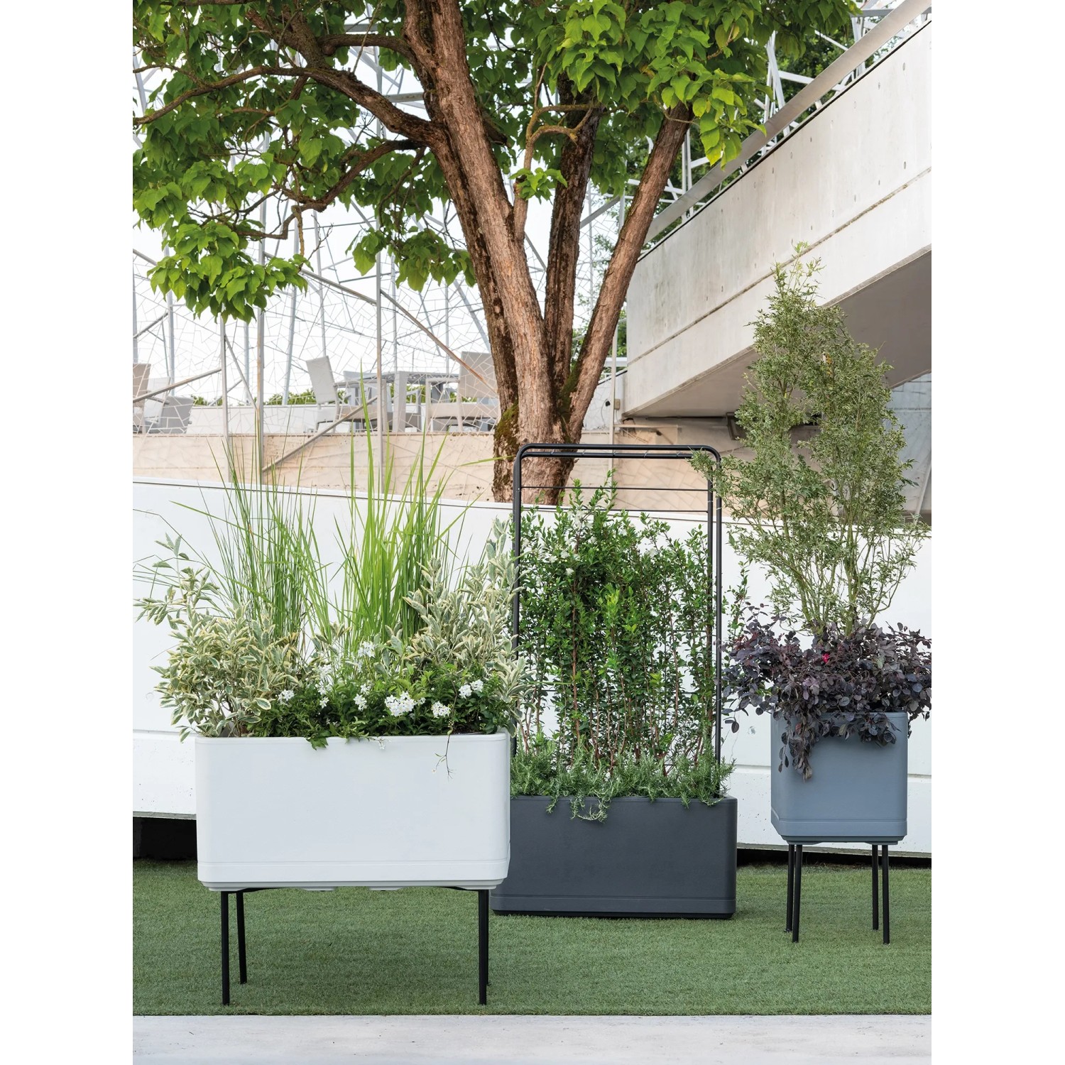 Fioriera Deroma Cosmo, 78 cm, bianco perla, con piante all'aperto.