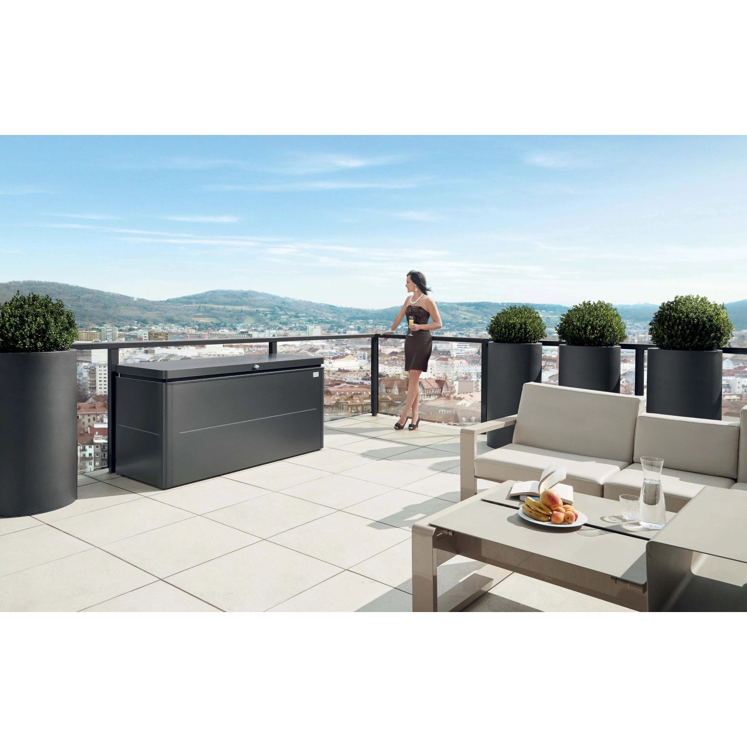 Biohort Loungebox 160 in grigio scuro metallizzato su una terrazza panoramica con vista sulla città.