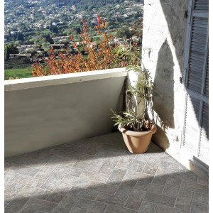 Piastrelle per pavimenti esterni posate su un balcone con una pianta in vaso.