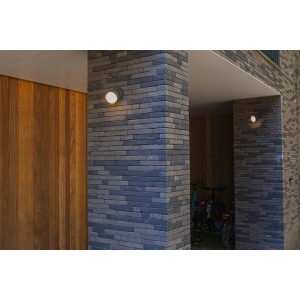 Moderna lampada da parete per esterni a LED Lutec Dropsi, antracite, montata su una parete di casa.