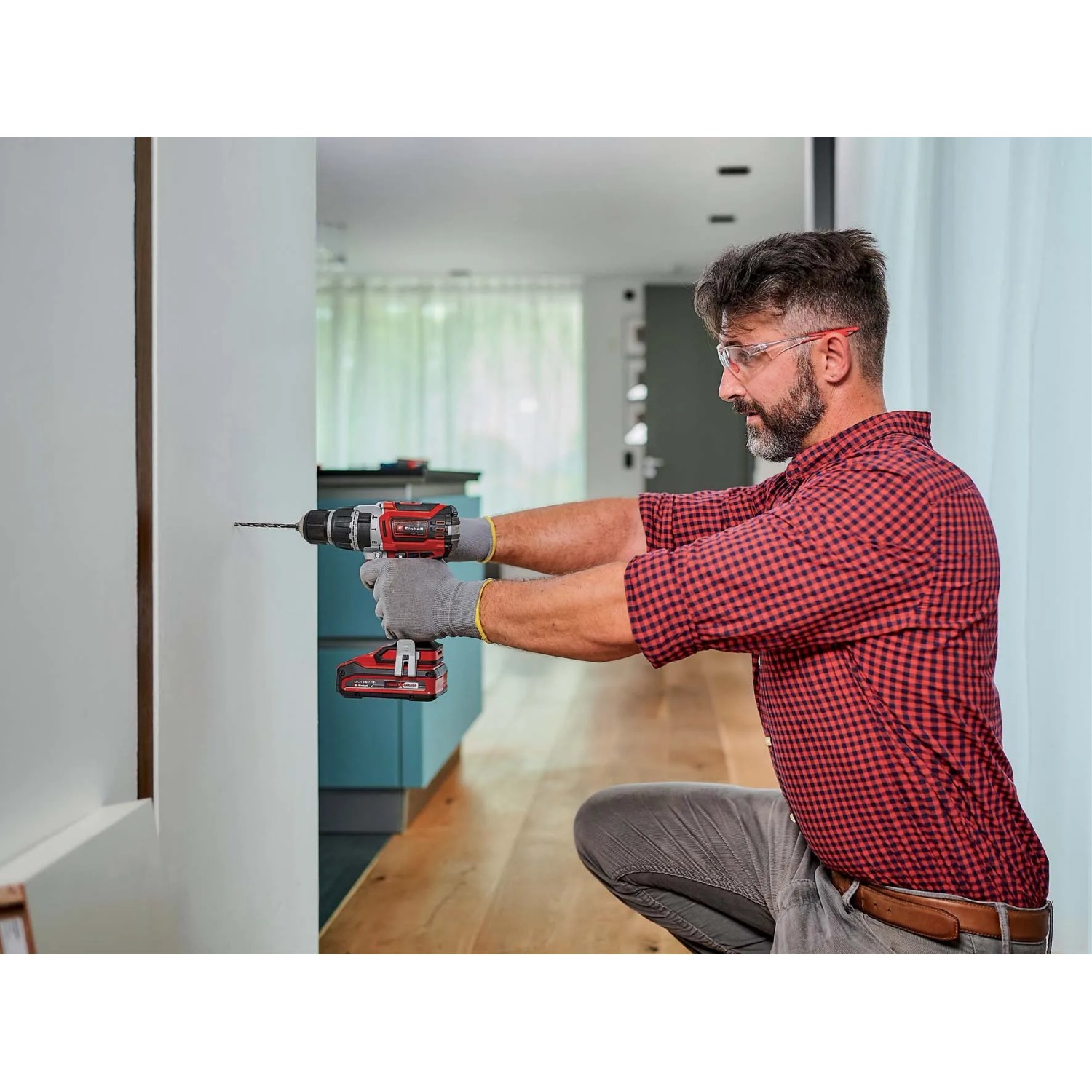 Avvitatore a impulsi a batteria Einhell TP-CD 18/60 Li-i BL Solo mentre fora un muro.