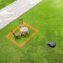 Scena con robot tagliaerba t.b.t. su prato con mobili da giardino.