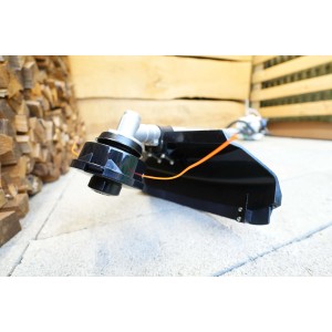 Dettaglio di un decespugliatore. Testina di taglio e protezione ben visibili.