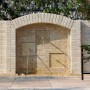 Muro decorativo in pietra con tre bocche come bordura per il giardino.