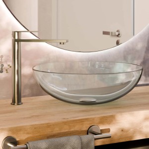 Lavabo in vetro trasparente con rubinetto su mobile in legno. Mobile bagno moderno.