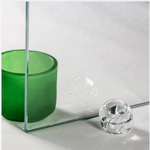 Pannello doccia in vetro trasparente t.b.t. con vetro verde e oggetto decorativo.