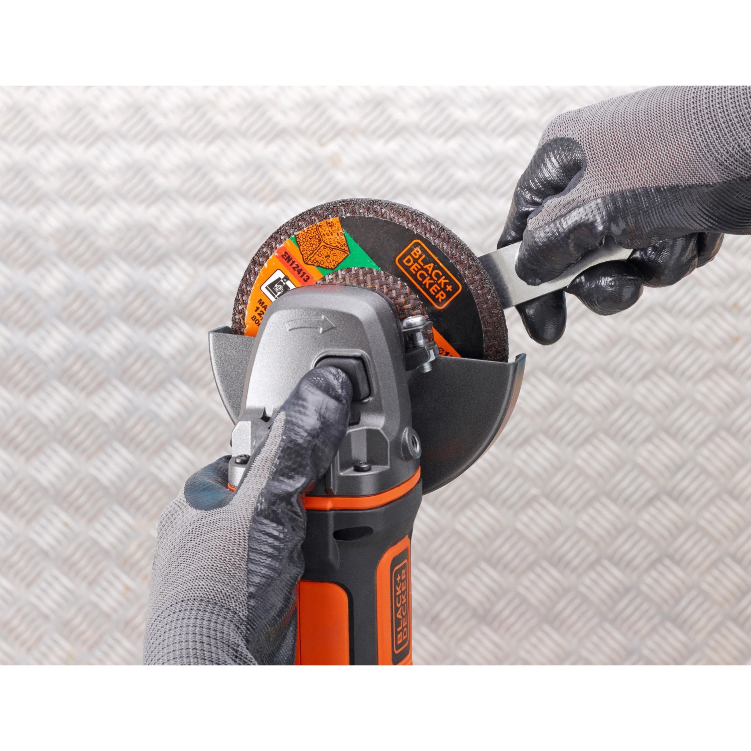 Smerigliatrice angolare a batteria Black+Decker BCG720N (solo corpo, 18 V, 125 mm) in azione.