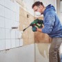 Uomo scalpella piastrelle con martello demolitore a batteria Bosch UniversalHammer 18 V. Utensile verde, senza filo 18V.