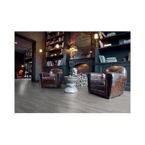 Pavimento laminato t.b.t. posato in soggiorno con poltrone e camino.