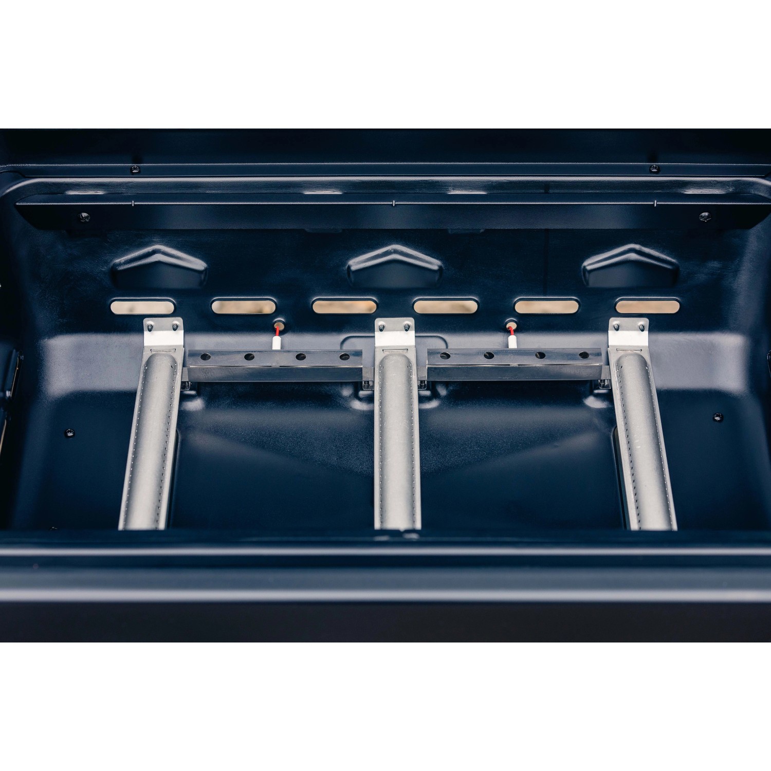 Vista interna del barbecue a gas con bruciatori. Accessori per barbecue.