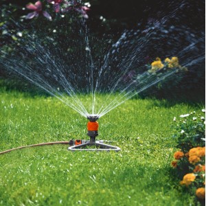 Irrigatore a settore Gardena Comfort Vario su slitta durante l'irrigazione di un giardino.