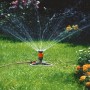 Irrigatore a settore Gardena Comfort Vario su slitta durante l'irrigazione di un giardino.
