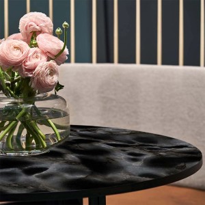 Tavolo con pellicola effetto marmo nero e vaso di fiori.