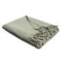 Coperta verde chiaro con motivo a treccia e frange, piegata.
