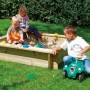 Sabbiera in legno con bambini che giocano in giardino.