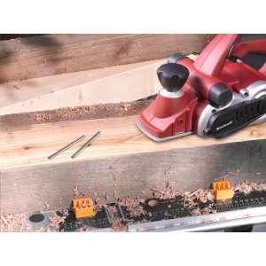 Set di 2 lame reversibili HM Einhell (82mm) per pialla, accanto alla pialla sul banco da lavoro.