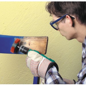 Uomo che utilizza spazzola a ventaglio LUX 100 mm su legno. Spazzola per trapano per rimuovere ruggine e vernice.
