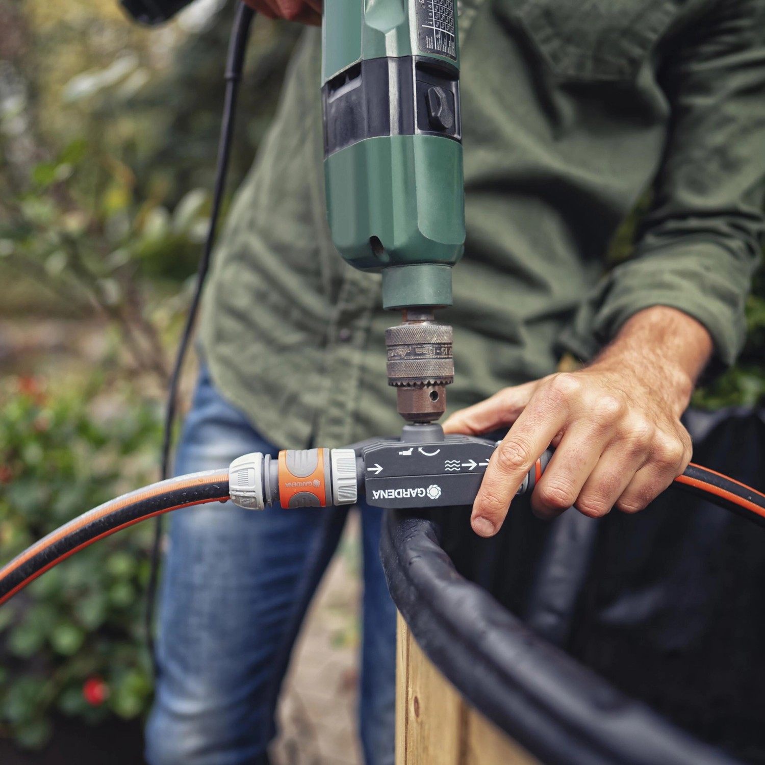 Pompa per trapano Gardena in uso con trapano e tubo per pompare l'acqua.